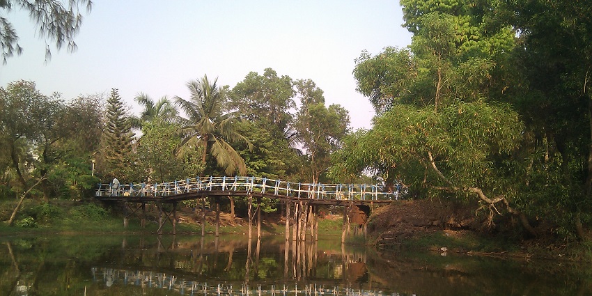 A bridge on the serene water at the Amarabati Park in the state of West Bengal.