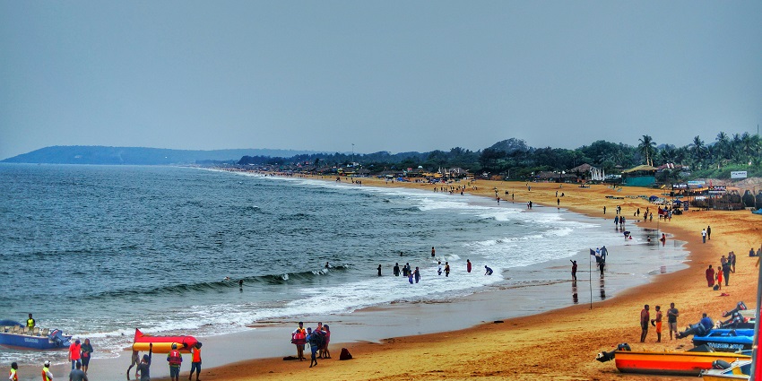 A picture of the beach including scenes of people engaging in surf sporting activities.