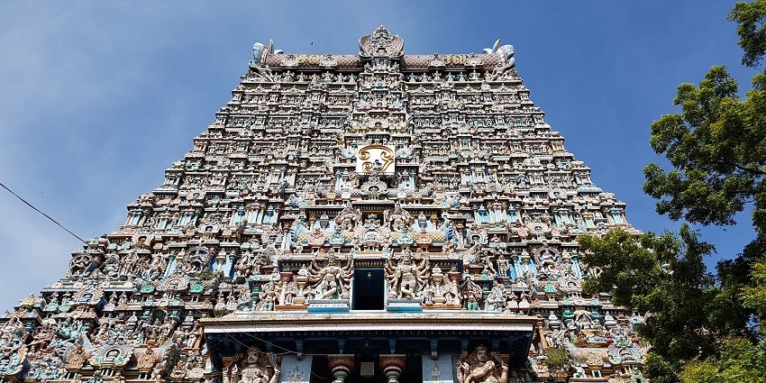 The ornate gopuram of the Meenakshi Temple in Madurai is adorned with vibrant sculptures.