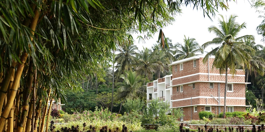 An ashram in lush greenery promoting spiritual growth and meditation practices.