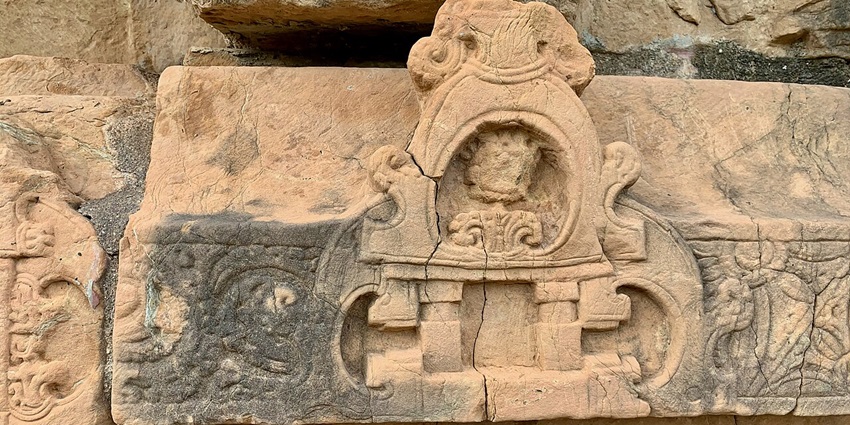 Intricate carvings and gavaksha motifs on the walls of an ancient temple.
