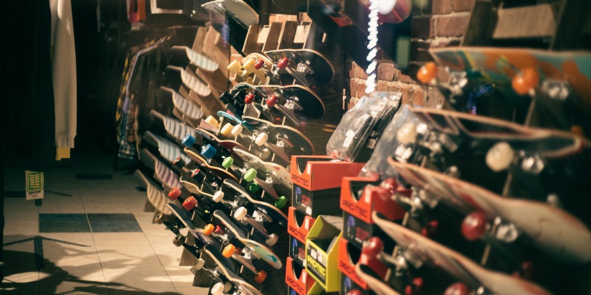 An image of Assorted skateboards and clothes in sports shop displayed prominently for buyers.