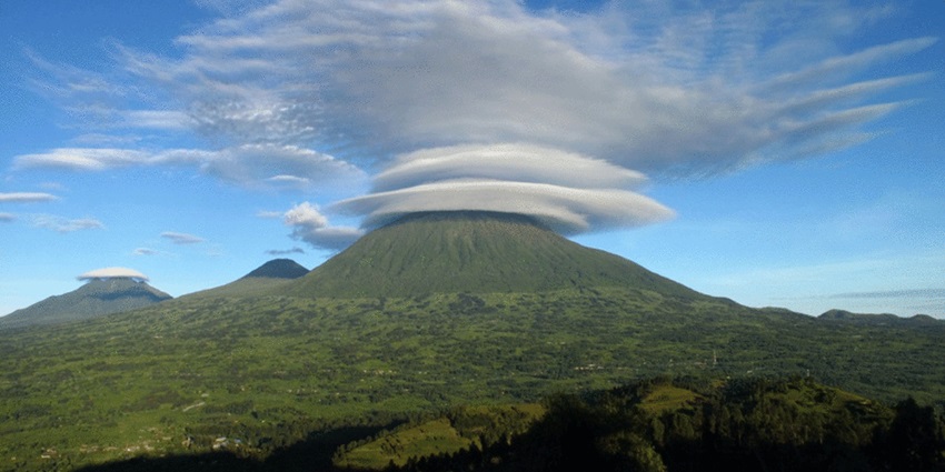 Volcanoes National Park with multiple volcanoes covered by clouds and disease greenery