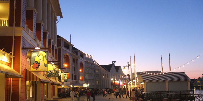 Boardwalk at Walt Disney World Resort in the evening lit with lights and visitors