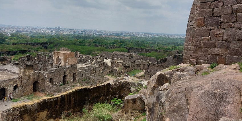 A hilltop fort with stone ruins and panoramic views of the Sahyadri ranges under a cloudy sky, one of the best things to see in Igatpuri.