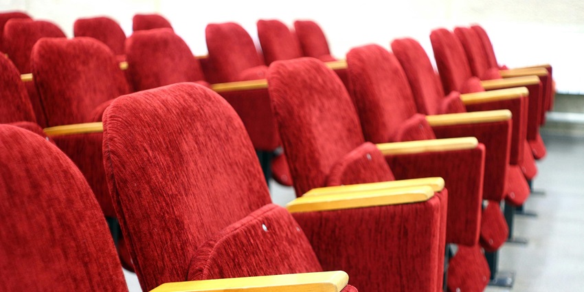 Image of red theatre chair in a row - enjoy a movie in MiniRamesh theatre with your friends and family