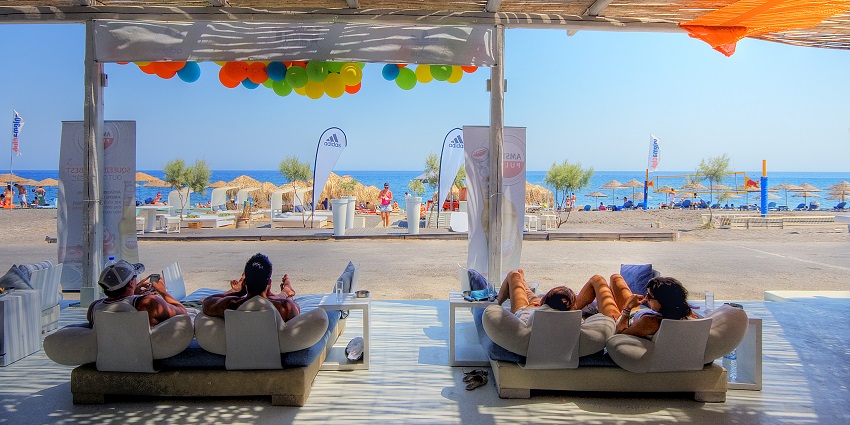 Wet stories bar with people lying on the couch enjoying their drinks near the beach.