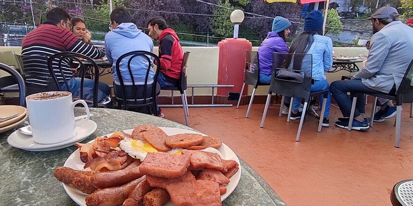 Tourists enjoying a meal together at a restaurant near Nanda Devi National Park