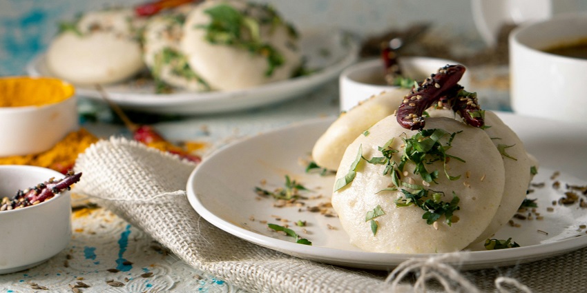 Traditional South Indian vadas served on a silver plate with sambar and coconut chutney.