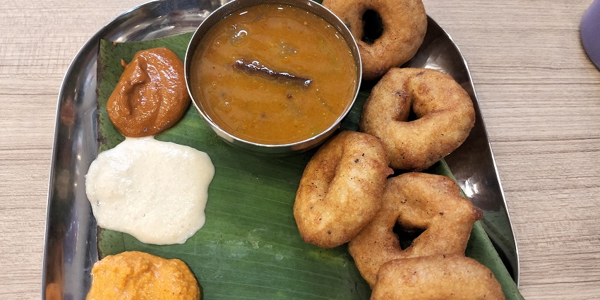 Traditional South Indian meal with vadas, sambar, and three chutneys