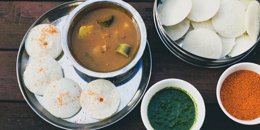 A South Indian dish known as Idli is served on a platter with other accompaniments.
