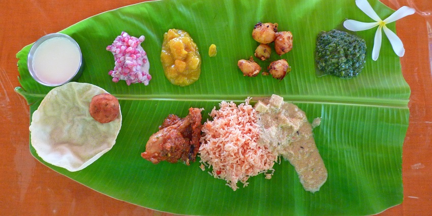 Traditional South Indian meal served on a banana leaf with rice and various curries.