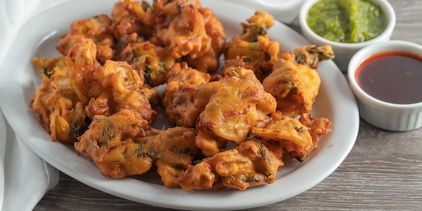 Image of aloo pakoda served on a white plate and creating a stylish indoor setting