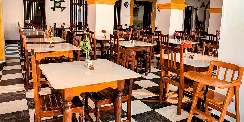 A rustic dining hall with wooden tables and chairs, image of a eatery nearby