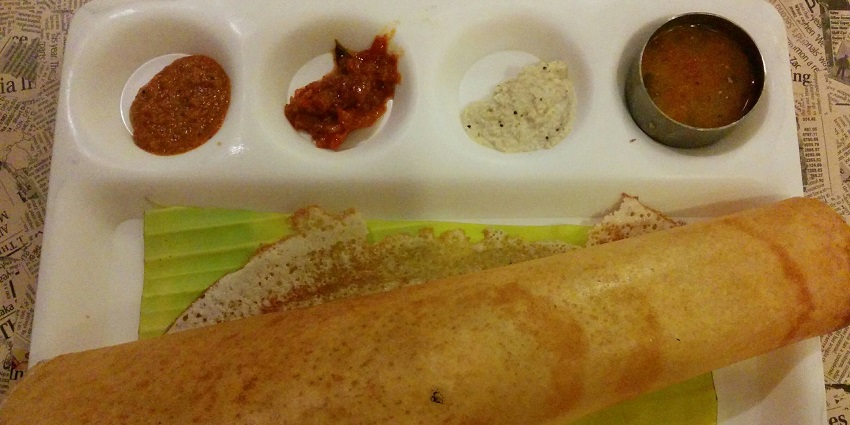 Crispy golden dosa served on a plate with sambar, coconut chutney