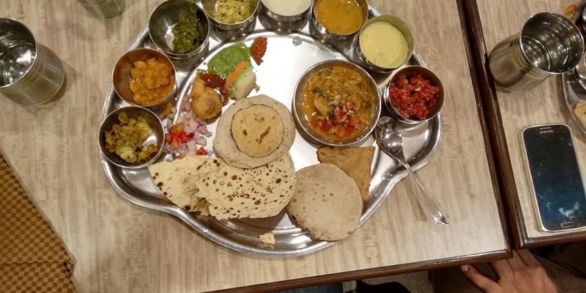 A traditional Indian thali featuring a variety of colourful dishes served in a restaurant