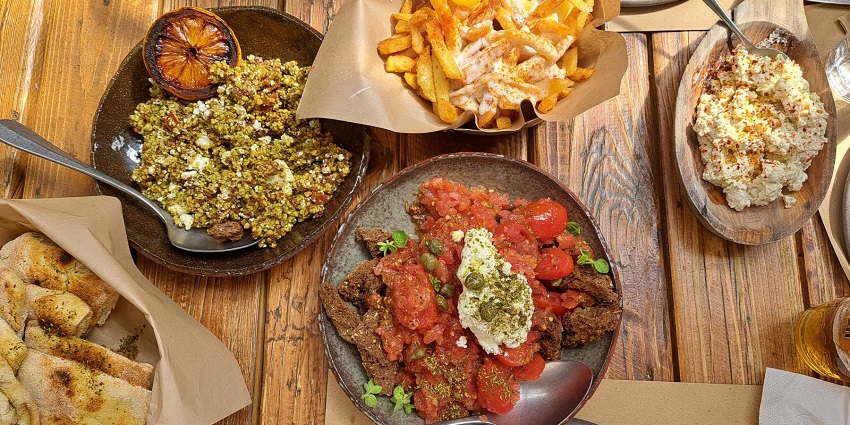Greek cuisine with dakos salad in the middle, tirosalata in the left and staka on top.