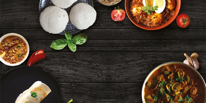 An array of typical South Indian meals, including dosas, and idlis, served with sambar.