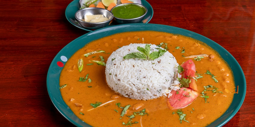 A North Indian thali served on plate, featuring various vegetable dishes, bread, and rice.