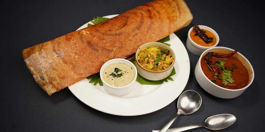 Overhead view of a traditional Tamil Nadu thali, featuring a variety of colourful dishes.