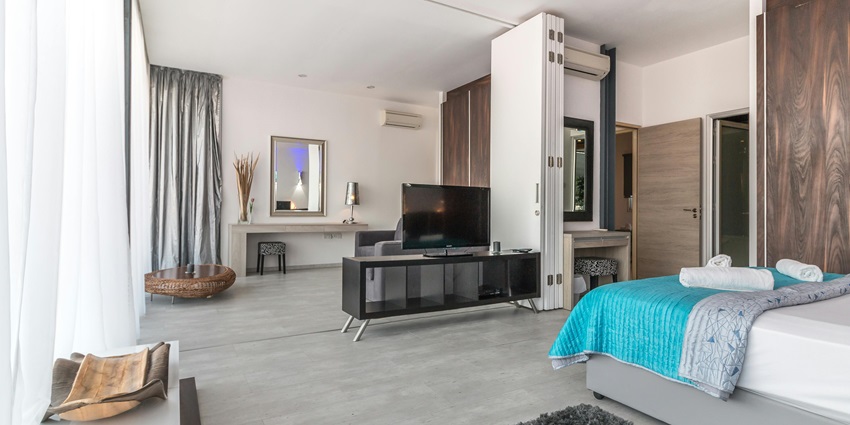 A modern bedroom featuring a large comfortable bed at a famous hotel near Nilansh Water Park.