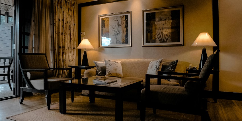 Cosy sitting area in a room with two lamps beside the two chairs, a sofa, and a table