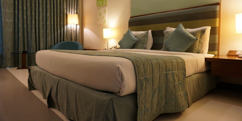 A hotel room with a bed, cosy lamp lights and modern furniture near Ranganatha Temple.