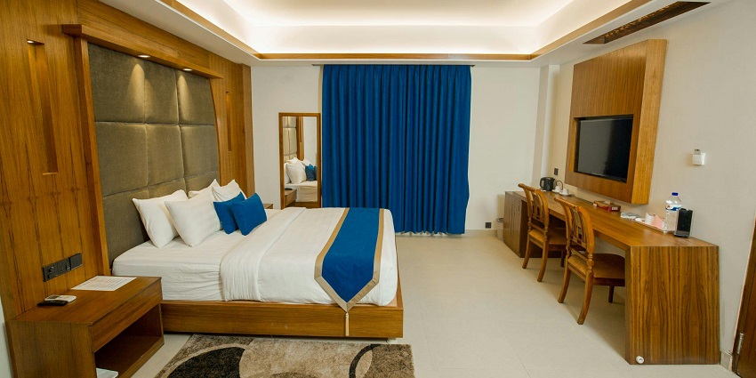 An image showing two beds and natural light in a hotel room near the Hogenakkal Waterfalls.