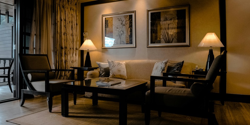 A living room featuring a brown wooden sofa set with cushions near Lucknow Zoo Museum.