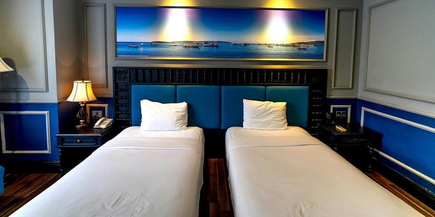 The hotel room interior features a modern design with a double bed and well lit ambiance.