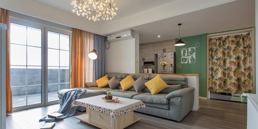 A cosy room with a grey sofa, colourful throw pillows, a wooden coffee table.