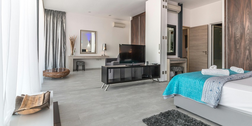 A stylish modern bedroom featuring a cosy bed, elegant decor, and warm lighting.