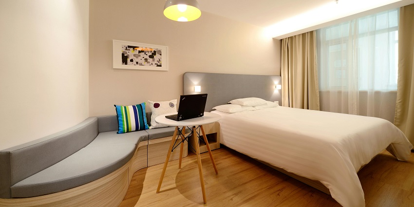 Stylish hotel bedroom with a comfortable workspace, perfect for relaxation and productivity