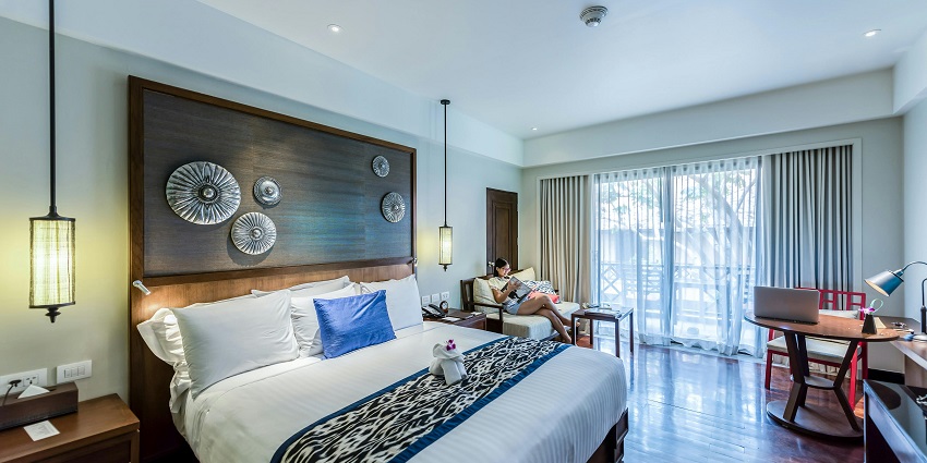 A cosy bedroom interior with modern decor, a neatly made bed, and soft lighting.
