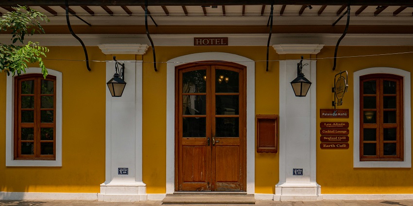 The entrance of a hotel with a modern design, featuring large glass doors