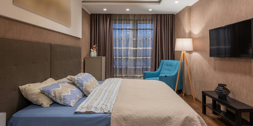 A cosy hotel room featuring a large bed, modern decor, and soft lighting