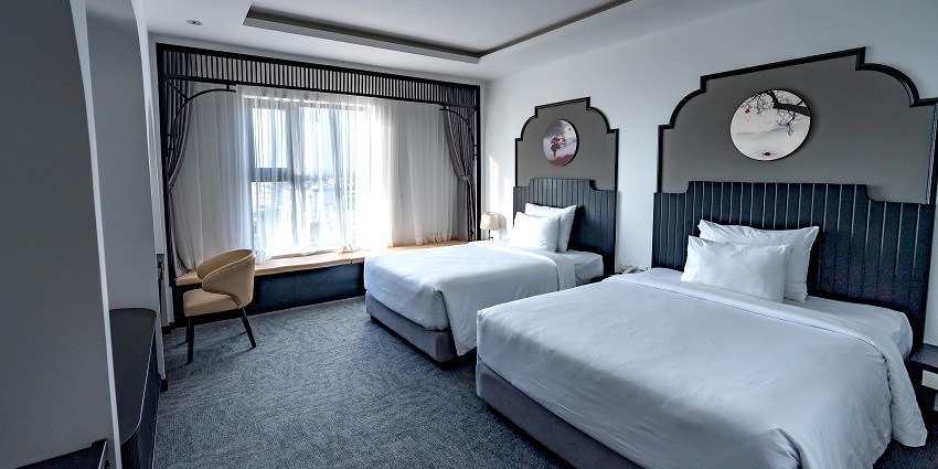 A view of a hotel room near Thiruparankundram temple with a book and a pair of eyeglasses.