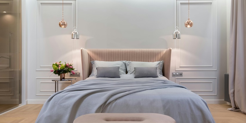 Image showing a hotel bedroom interior with a bed near a table under lamps.