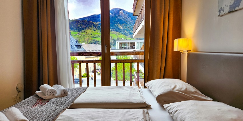 A picture of a hotel room with all the amenities and a beautiful view visible from the balcony