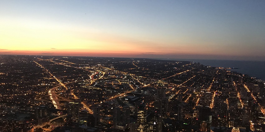 Chicago City from above the Willis Tower Skydeck with tall buildings and roads lit at night
