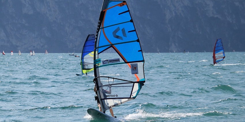 A picture of a guy windsurfing and enjoying one of the top Nagaon Beach water sports.