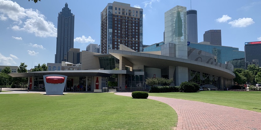 World of Coca-Cola entrance with a model coke bottle, and trees on either side