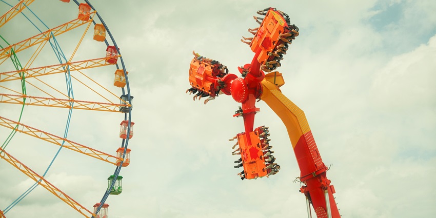 An image of a colourful amusement park filled with exciting rides and water attractions.