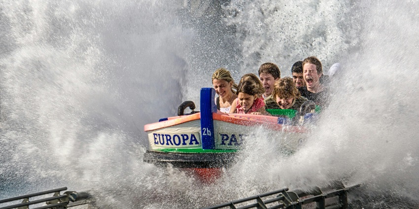 An image showing children enjoying a thrilling ride on a colourful water slide at a water park.