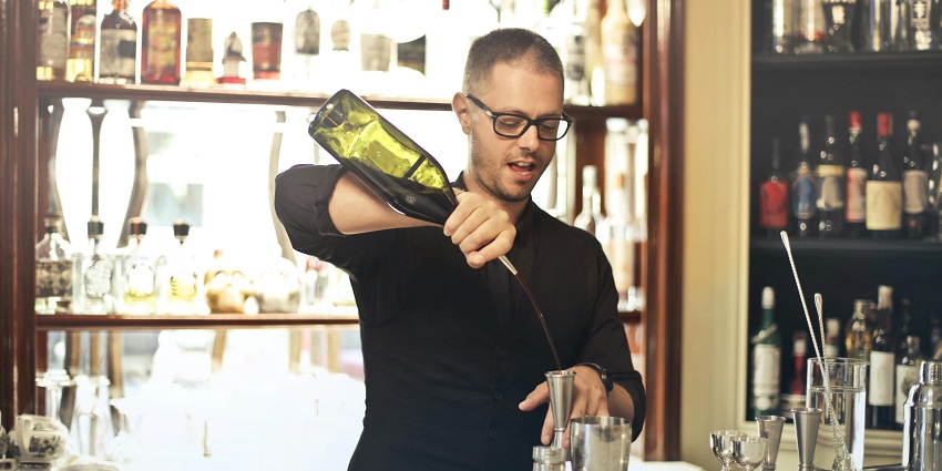 A bartender using a shaker to mix the cocktails at a bar in Santorini.