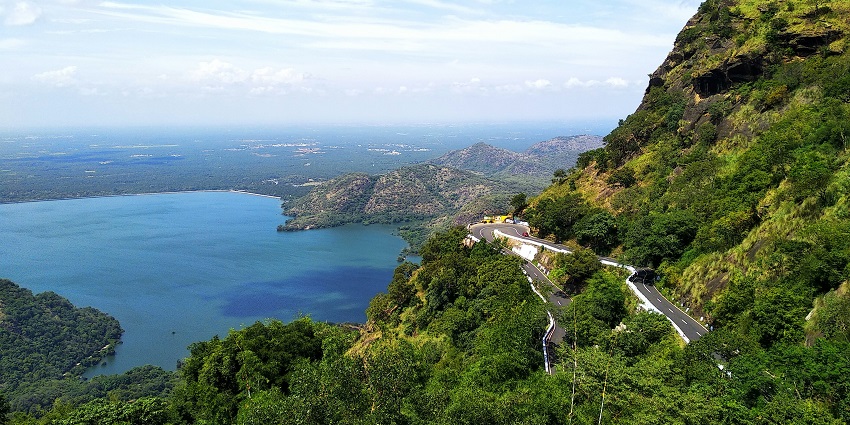 People boating on the Yercaud Lake surrounded by greenery and others waiting on the side.
