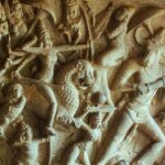 Intricate ancient Indian stone relief sculpture with detailed carvings of figures