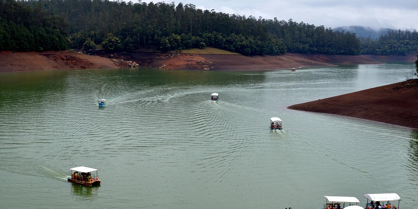 Boating on the calm waters of Pykara Lake, surrounded by lush green hills and trees.