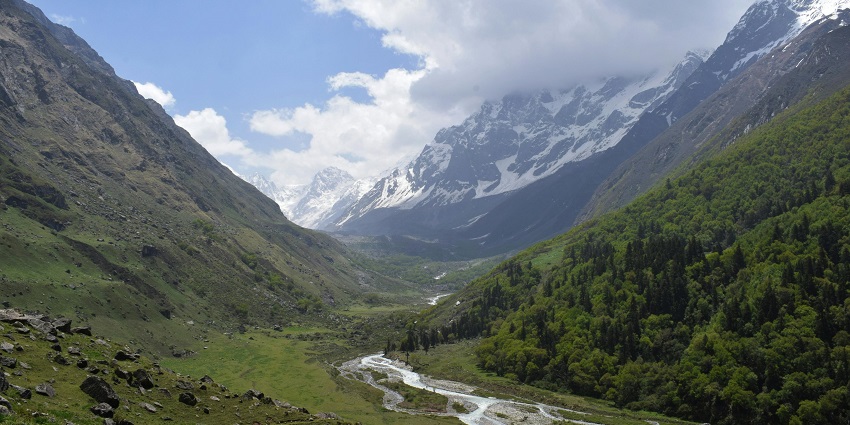 An image of beautiful Sahastradhara waterfalls surrounded by lush green hills.