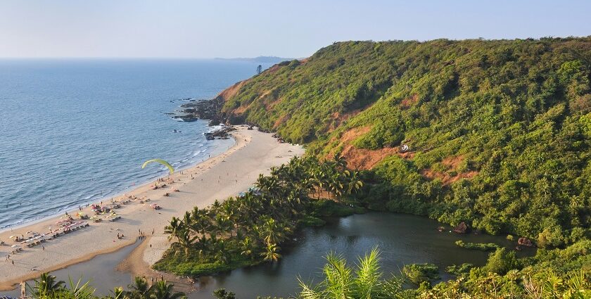 Scenic beach view from above, showing turquoise waters, sandy shore, and lush green surroundings